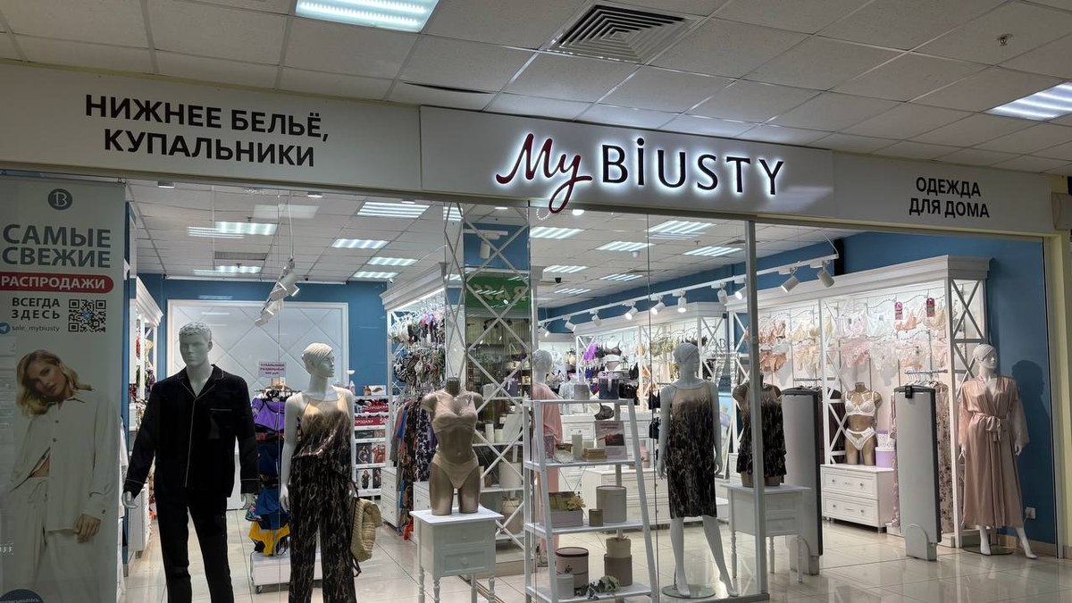 Витрина салона MyBiUSTY в торговом центре: вывеска над стеклом, за ним манекены и стойки с бельём